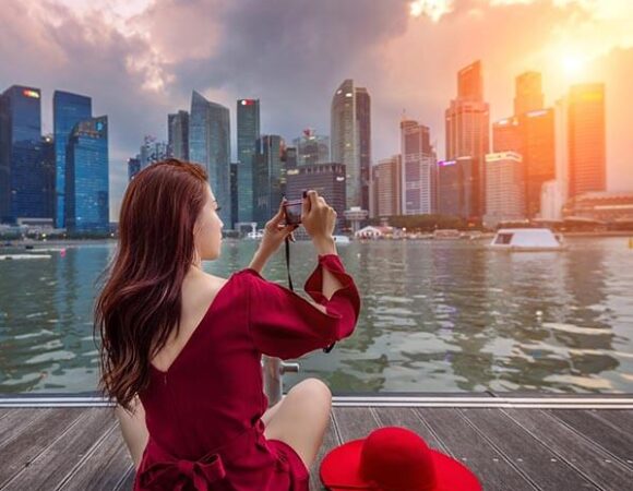 Tour Singapore Trọn Gói cô gái ngồi chụp selfie bên vịnh Marina Bay Sands